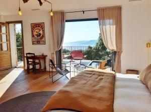 a bedroom with a bed and a balcony with a view at U Castellu Chambres d'hôtes & Location villa et appartements vue mer in Propriano
