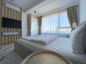 a bedroom with a large bed with a large window at North Star Apartment 15 in Timişoara