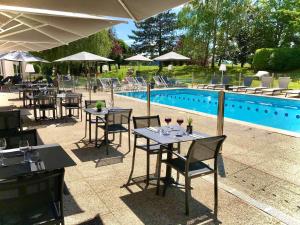 a restaurant with tables and chairs next to a pool at Novotel Beaune in Beaune