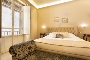 a bedroom with a large bed and a window at Maecò Ortigia B&B in Syracuse