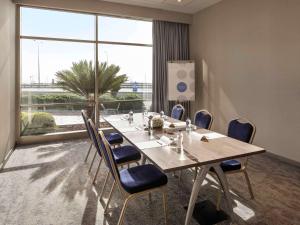 een vergaderzaal met een tafel en stoelen en een groot raam bij Novotel Istanbul Zeytinburnu in Istanbul