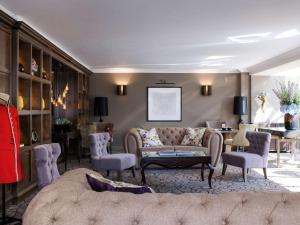 a living room with a couch and a table at Castle Hotel Windsor in Windsor