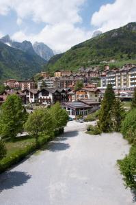 a river in front of a town with mountains at Albergo Italia in Molveno