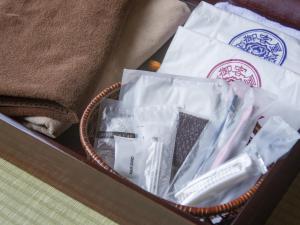 kosz z ręcznikami i innymi rzeczami w obiekcie Okyakuya w mieście Minamioguni