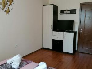 a room with a bed and a television and a door at Villa Mareli in Tsarevo +22 photos