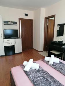 a room with two beds and a flat screen tv at Villa Mareli in Tsarevo