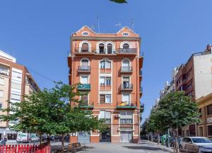 a tall orange building on the side of a street at Apartment Ruzafa Market I in Valencia