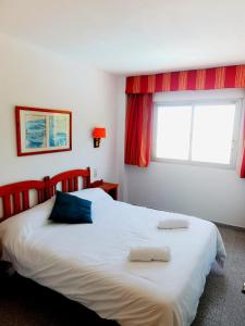 a bedroom with a large bed with two pillows on it at Apartamentos Quintasol in Malgrat de Mar