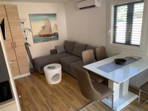 a living room with a couch and a table at MALI NORDSEE Mobilehomes , Glamping & Caravan in Pakoštane