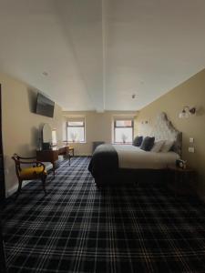 a bedroom with a large bed and a desk at The Lounge Hotel & Bar in Penrith