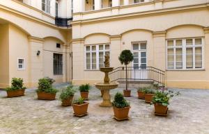 a fountain in front of a building with potted plants at NN Apartman Budapest in Budapest
