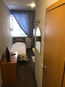 1 dormitorio con cama, escritorio y ventana en Rinaldi at Petropavlovskaya, en San Petersburgo