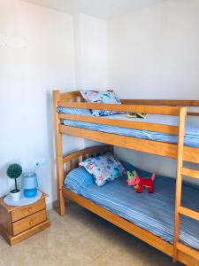Un dormitorio con dos literas con un juguete de dinosaurio. en Apartment Papa Luna, en Peñíscola