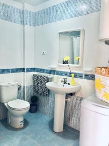 Un baño con inodoro, lavabo y espejo. en Apartment Papa Luna, en Peñíscola