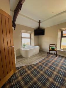 a large bathroom with a white tub in a room at The Lounge Hotel & Bar in Penrith