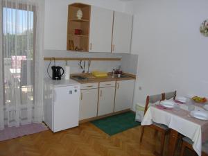 eine Küche mit einem Tisch und einem weißen Kühlschrank in der Unterkunft Apartments Jadranka with magnificent views of the sea - Baska in Baška + 6 Fotos