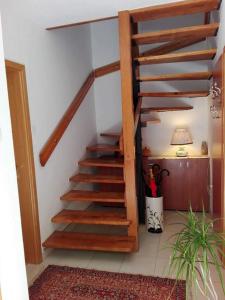 a wooden staircase in a room with a plant at Apartments JADRANKA with magnificent views of the sea - Baska in Baška
