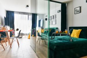 ein Wohnzimmer mit einem grünen Sofa und einem Tisch in der Unterkunft EASY RENT Apartments - Diamond in Lublin