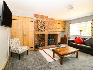 a living room with a couch and a fireplace at Keepers Cottage in Beeston