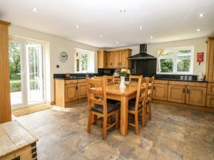 a large kitchen with a wooden table and chairs at Keepers Cottage in Beeston