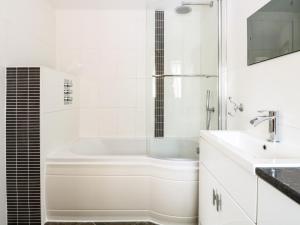 une salle de bain blanche avec une baignoire et un lavabo dans l'établissement Keepers Cottage, à Beeston 17 autres photos