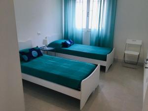 2 posti letto in una piccola stanza con lenzuola blu di Casa Amelia a Marina di Grosseto