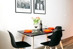 a dining room table with black chairs and a bottle of wine at EASY RENT Apartments - Crystal, Basen & SPA, Centrum, 24h Check-in in Lublin