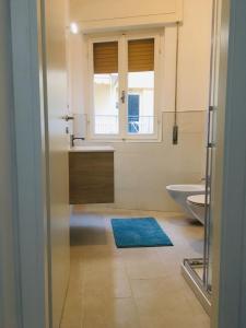 bagno con lavandino, servizi igienici e finestra di Casa Amelia a Marina di Grosseto