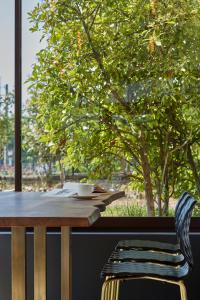 une table en bois et une chaise à côté d'une fenêtre dans l'établissement Maison Cabotte, à Beaune