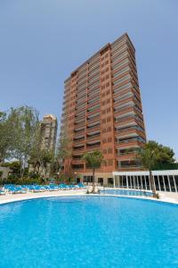 a large swimming pool in front of a tall building at Aparthotel BCL Levante Lux in Benidorm