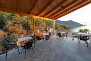 una terraza con mesas y sillas y vistas al agua en Paraskevas Boutique Hotel, en Tyros