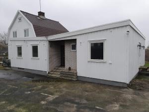 una casa blanca con garaje en Centralt i Falkenberg, en Falkenberg