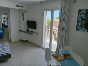 un soggiorno con tavolo e TV di Residence Valentina - Apartment Laura int 9 a Santa Maria al Bagno