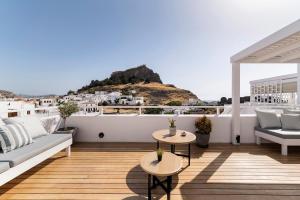 a balcony with a couch and tables and a view at Lindian Polis in Lindos