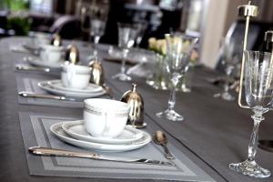 a table with plates and cups and glasses on it at B&B N°5 in Liège