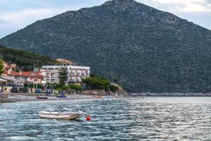 un barco en el agua con una montaña en el fondo en Paraskevas Boutique Hotel en Tiros