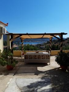 a wooden gazebo with a table on a patio at Elaia country living in Galatas