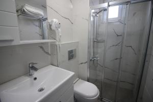 a bathroom with a shower and a toilet and a sink at Nilada Bozcaada in Bozcaada