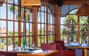 a dining room with tables and chairs and a large window at Hotel Botanico y Oriental Spa Garden in Puerto de la Cruz