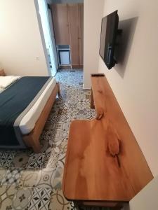a bedroom with a bed and a tv and a wooden bench at Akcapinar Korfez Butik Otel in Akyaka