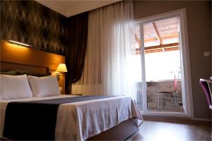 a hotel room with a bed and a window at Rhisos Otel in Rize