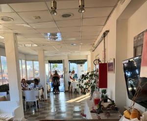 una stanza con persone sedute ai tavoli in un ristorante di Hotel Belvedere a Sanremo