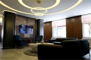 a lobby with chairs and a table and a ceiling at Rhisos Otel in Rize