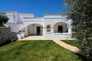 a white house with a lawn in front of it at AGRITURISMO Masseria Spetterrata in Cisternino