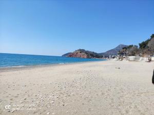 einen Strand mit Fußabdrücken im Sand und im Ozean in der Unterkunft Apartment Perutović in Sutomore