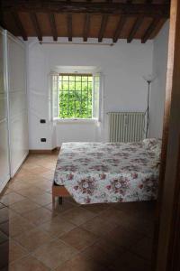 1 dormitorio con cama y ventana en Casa Vacanza Il Laghetto Bea, en Dicomano