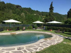 una piscina con sombrillas y sillas en un patio en Casa Vacanza Il Laghetto Bea, en Dicomano