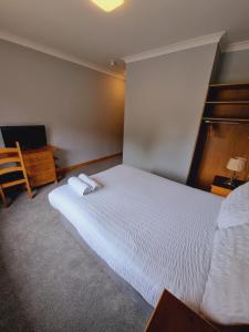 Een bed of bedden in een kamer bij Ardilaun Guesthouse Self Catering