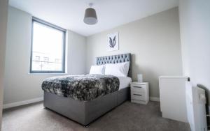 a bedroom with a white bed and white walls at Dream Luxury Serviced Apartments Manchester in Manchester