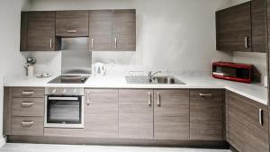 a kitchen with a sink, stove, microwave and refrigerator at Dream Luxury Serviced Apartments Manchester in Manchester